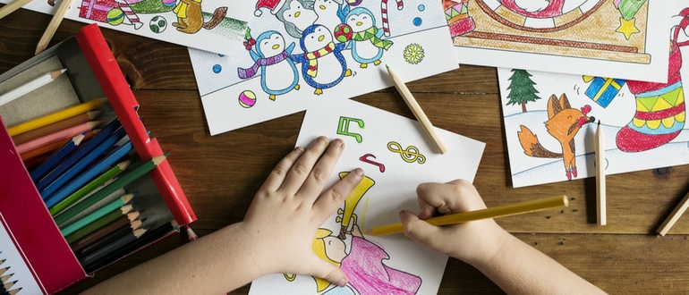 ребенок рисует карндашами